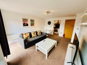 a living room with a couch and a table at Exquisite City Centre Apartment - 2 Bed 2 Bath - Free Parking - Netflix Amazon Disney Enabled Smart TV in Birmingham
