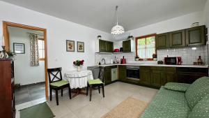a kitchen with a couch and a table in it at Zöld 21 Cottage in Őrtilos