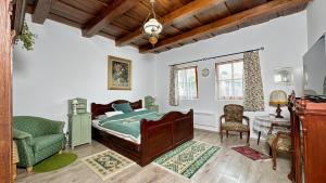 a bedroom with a bed and a chair at Zöld 21 Cottage in Őrtilos