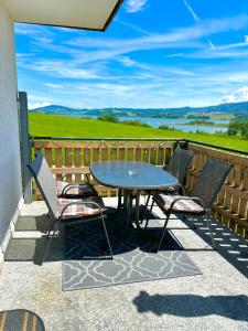 a table and chairs on a patio with a view at Gästhaus "Seeblick" in Seekirchen am Wallersee