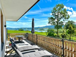 a balcony with a table and an umbrella at Gästhaus "Seeblick" in Seekirchen am Wallersee