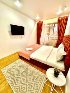 a bedroom with a bed and a flat screen tv at ЖК МАДИНА ЕВРА ДВУШКА in Kokshetau