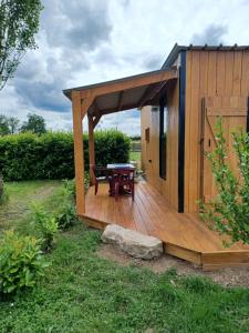 a wooden gazebo with a picnic table on a deck at Tiny House in Fleury-sur-Loire