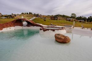 a swimming pool with a rock in the water at Valle de la Luna in Tandil