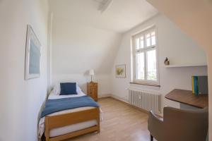 um quarto com uma cama, uma secretária e uma janela em Charmante Altbauwohnung am Rhein em Basileia