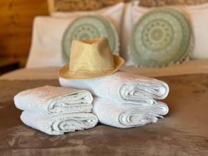 a pile of towels with a hat on a bed at Wooden Summer House in Mantoúkion +24 photos