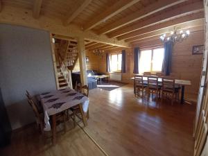 a dining room and living room with a table and chairs at Dom goralski Kamilux in Nowy Targ