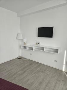 una sala de estar blanca con TV en una pared blanca en 10housemamaia, en Năvodari