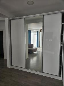 Habitación con puertas correderas de cristal y sofá en 10housemamaia, en Năvodari