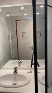 a bathroom with two sinks and a large mirror at Skis aux pieds station 1600 Sun Vallée in Puy-Saint-Vincent