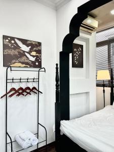 a bedroom with a black and white bed and a window at Indochine Design Apartment Hotel 5 - Hanoi Old Quarter in Hanoi
