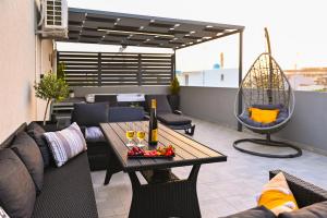 patio con divano e tavolo con bicchieri da vino di Home sweet home jaccuzi a Heraklion