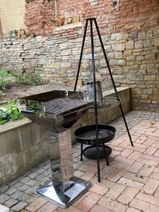 a barbecue grill with a stand in a courtyard at Gästehaus Geiseltalsee in Mücheln