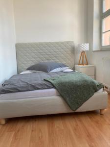 a bedroom with a bed with a green blanket on it at Gästehaus Geiseltalsee in Mücheln