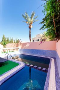 une piscine avec un palmier en arrière-plan dans l'établissement Zine Villa Guest House, à Marrakech