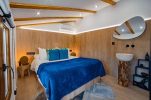 a bedroom with a bed with a blue comforter at Los parajes de Alcalá in Alcalá del Júcar +15 photos