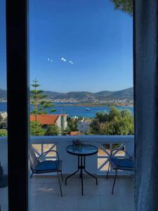 a balcony with a table and chairs and a view of the water at Panoramic Sea View in Porto Rafti