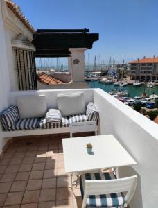 d'une terrasse avec un canapé et une table sur un balcon. dans l'établissement Apartamento Puerto Deportivo Almerimar, à Almerimar