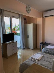 a bedroom with a bed and a tv and a window at Studio with unique view near the beach! in Porto Rafti