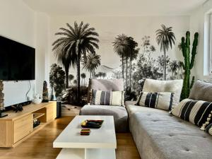 a living room with palm trees on the wall at Maison proche du vieux Lille et de la citadelle avec place parking in Lambersart