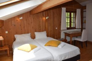 1 dormitorio con 2 camas con almohadas amarillas en Chalet L'Olan 15 pers. 6 rms + terrain en Les Deux Alpes