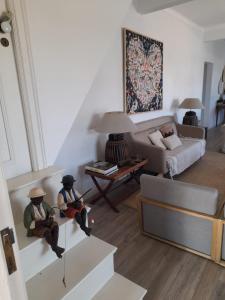 una sala de estar con dos hombres sentados en las escaleras en Moradia de férias Casa do Chorão - Montargil, en Montargil