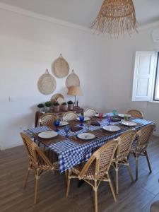 mesa de comedor con sillas y mantel azul y blanco a cuadros en Moradia de férias Casa do Chorão - Montargil, en Montargil