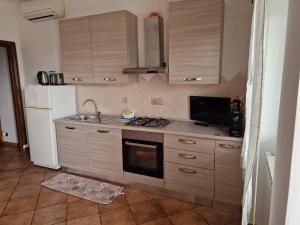 a kitchen with a stove and a sink and a refrigerator at La casa tra gli ulivi di Fonte Nuova 1 in Fonte Nuova