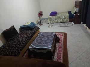een woonkamer met 2 bedden en 2 tapijten bij Chambre chez l'habitant avec famille in Agadir