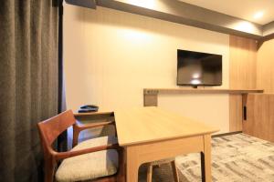 成田市にあるリッチモンドホテル成田のテーブルと薄型テレビ付きの客室です。