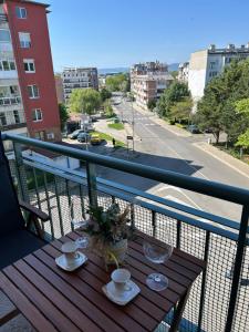 a table on a balcony with a view of a street at Nesebar City Apartment in Nesebar