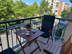 a wooden table and a chair on a balcony at Nesebar City Apartment in Nesebar