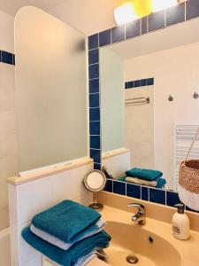 uma casa de banho com um lavatório e um espelho em Appartement rez-de-chaussée entre dunes et ocean em Lacanau-Océan