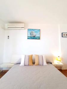 a white bedroom with a bed with two pillows at Sea Views Benidorm Beach in Benidorm