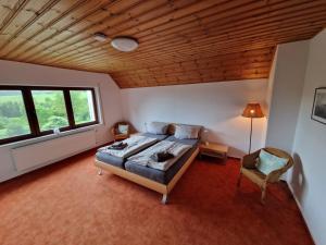 a bedroom with a bed and a wooden ceiling at Eifel Ferienhaus Luna in Ohlenhard