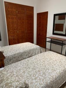 two beds in a room with two doors and a mirror at LA BARRACA - A - Relax, Terraza cerca del mar in Mojácar