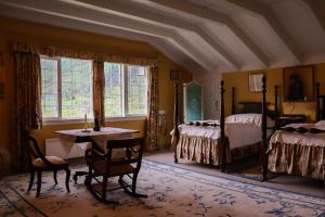 a bedroom with two beds and a table and a desk at Singerheimen in Olden
