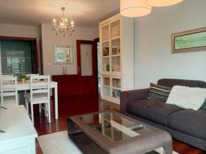 Apartamento Familiar SARDINERO RH 20 في سانتاندير: غرفة معيشة مع أريكة وطاولة