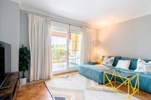 a living room with a blue couch and a window at LA QUINTA ISLA CANELA GOLF by MSHOLIDAYS in Isla Canela +33 photos