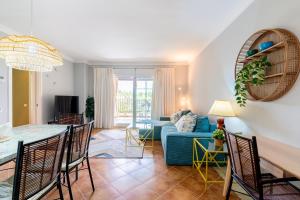 a living room with a blue couch and a table at LA QUINTA ISLA CANELA GOLF by MSHOLIDAYS in Isla Canela