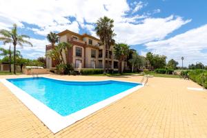 a villa with a swimming pool in front of a house at LA QUINTA ISLA CANELA GOLF by MSHOLIDAYS in Isla Canela