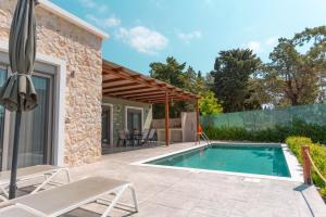 a swimming pool in the backyard of a house at Oliveto A Flumine - Experientia Villa in Pastida