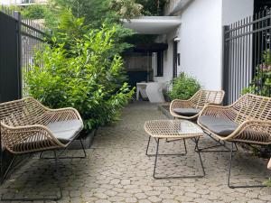 three wicker chairs sitting on a patio at the birdy mountains luxury lodge in Schlitz