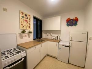 Tal-GħoqodにあるSt Julians Property with Terraceの白いキャビネットと白い冷蔵庫のあるキッチン