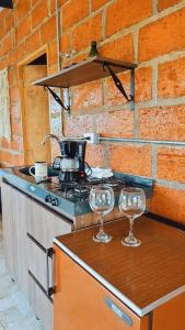 a kitchen with two wine glasses on a counter at EcoCamp - San Carlos Cabine Home in San Carlos