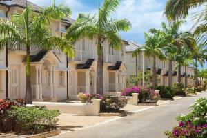 a row of houses with palm trees and flowers at Blue Horizon Battaleys Mews lovely secure villa 5 minutes from Mullins beach in Saint Peter