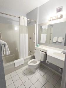 a bathroom with a toilet and a tub and a sink at Heritage House Inn in Hyannis