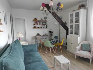 uma sala de estar com um sofá azul e uma mesa em La Belle Vie Ouistreham Riva Bella Résidence Hastings em Ouistreham