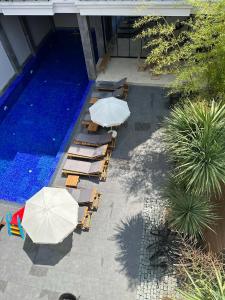 a group of chairs and umbrellas next to a pool at Hotel Homey Kobuleti in K'obulet'i