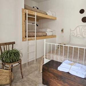 a room with a bunk bed and a chair and a table at Nel Borgo di San Francesco - Casa vacanze in centro in Villa Santa Maria
